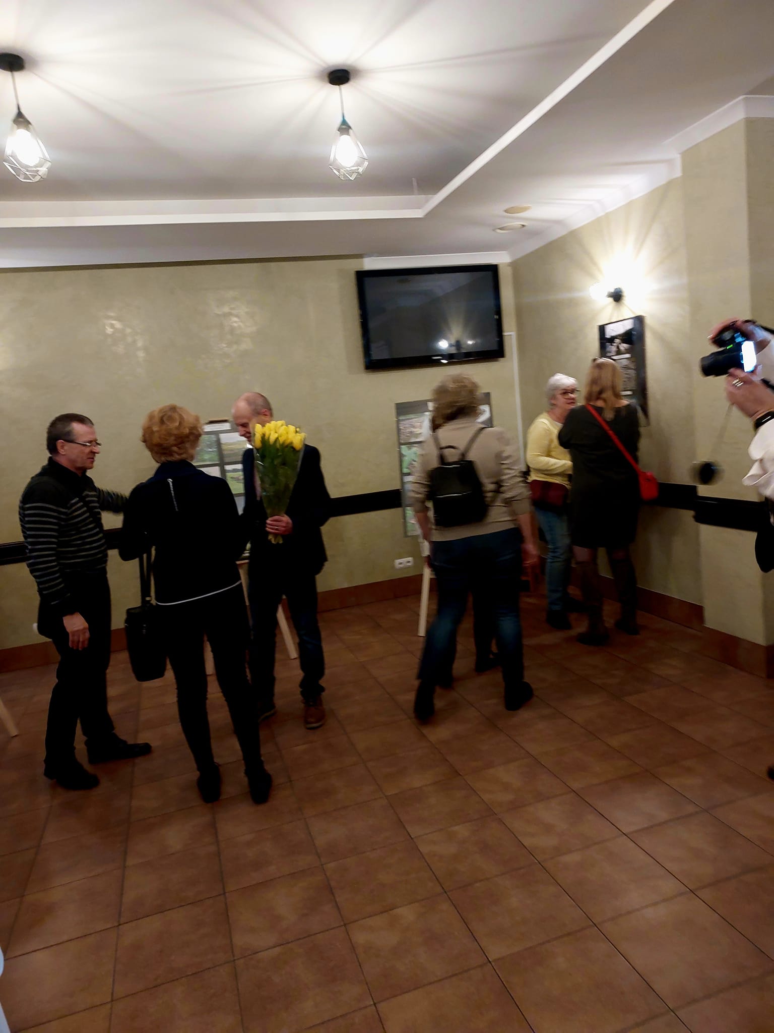 Die Besucher betrachten die Fotoausstellung mit Interesse.