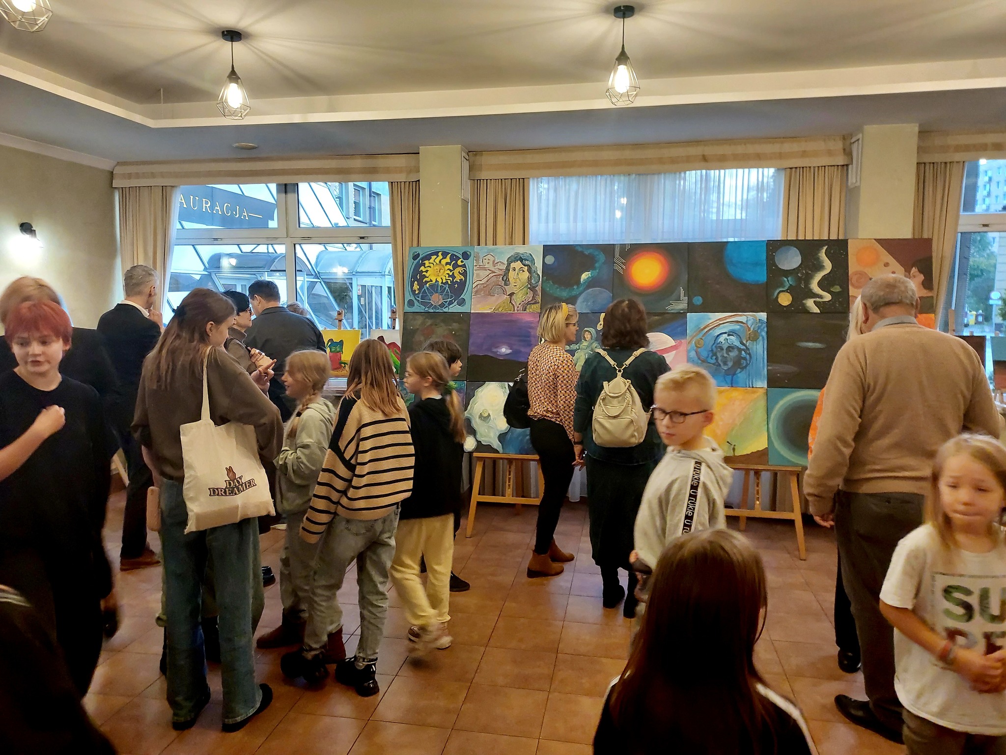 Geladene Gäste besichtigen eine Ausstellung von Werken.
