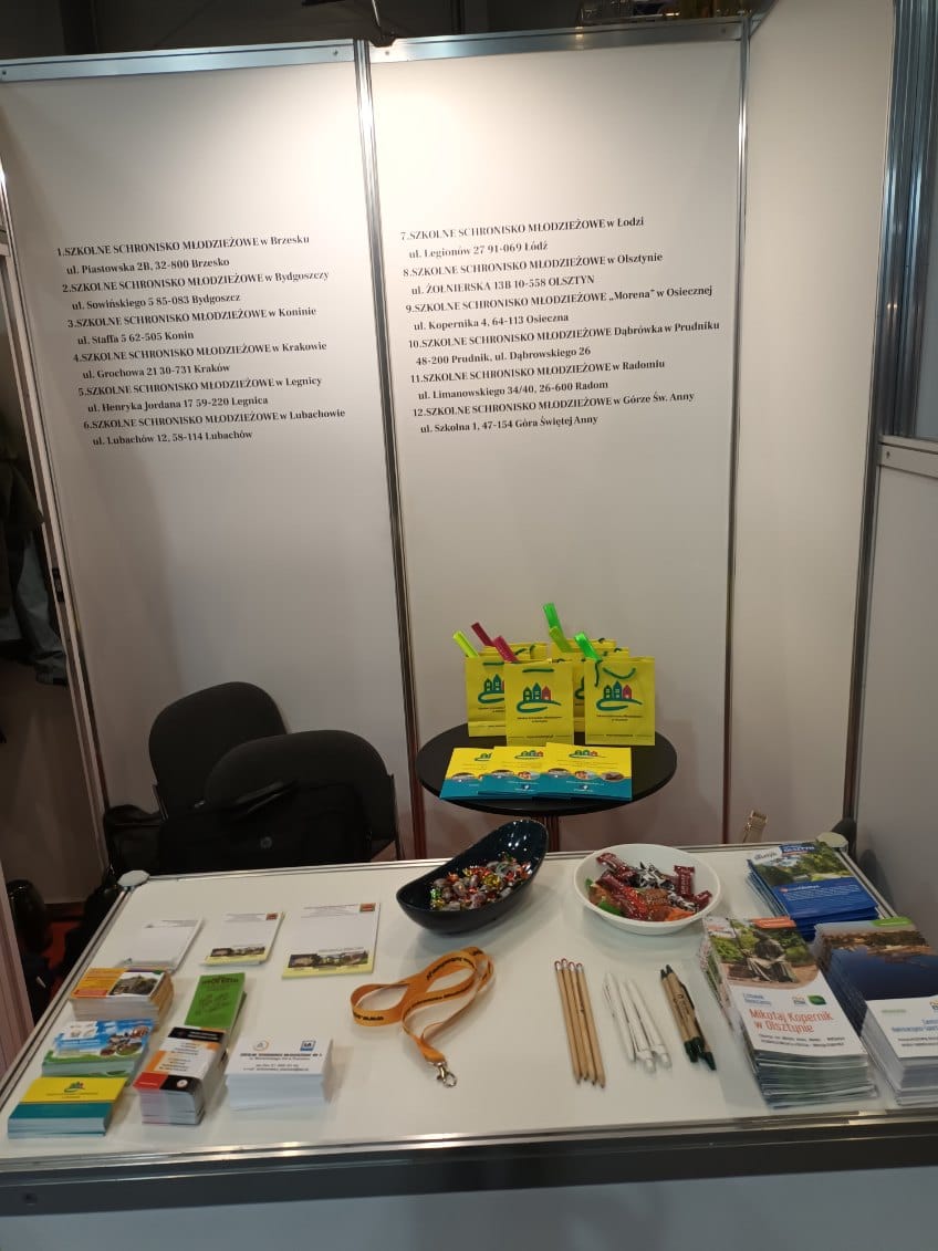 Presentation of advertising materials on the counter of the stand of various shelters. In the background - the name and addresses of shelters participating in the fair.